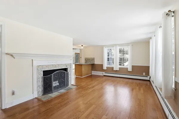 a view of a livingroom with wooden floor and a fireplace