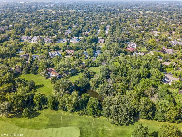 an aerial view of residential houses with outdoor space and trees