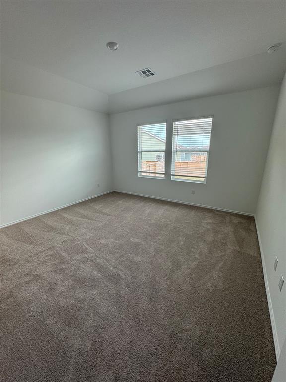 216 Jeffers Kyle, TX 78640 - Photo 13 of 19 Spacious room featuring neutral-toned carpet flooring, white walls, and a tray ceiling