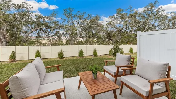 a view of a patio with couches chairs under an umbrella