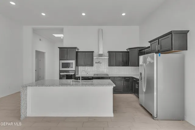 a kitchen with refrigerator and cabinets
