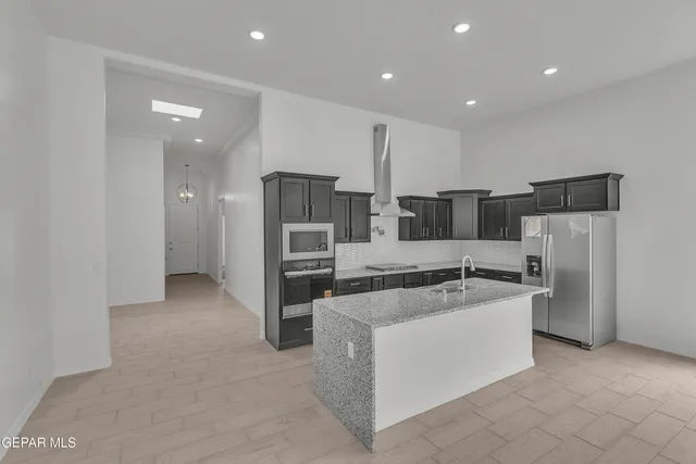 a kitchen with stainless steel appliances a refrigerator and a stove