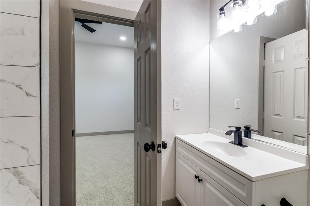 917 South Carroll Avenue Dallas, TX 75223 - Photo 20 of 30 Bathroom with a textured wall, vanity, ceiling fan, and carpet floors