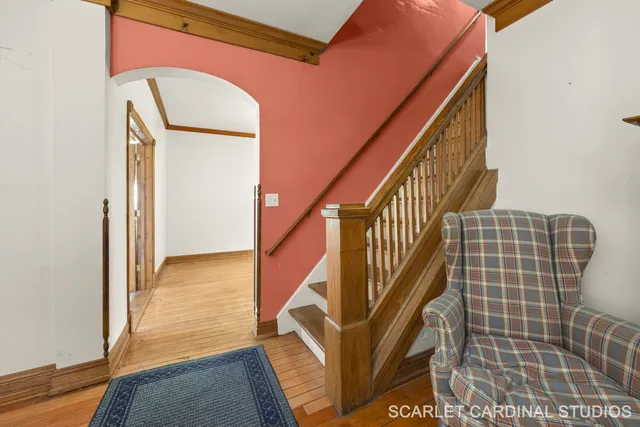 an empty room with wooden floor chandelier and windows