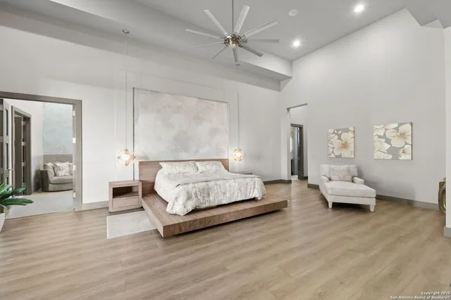 a spacious bedroom with a bed and wooden floor