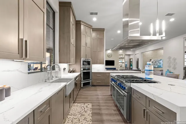 a kitchen with stainless steel appliances a sink stove and cabinets