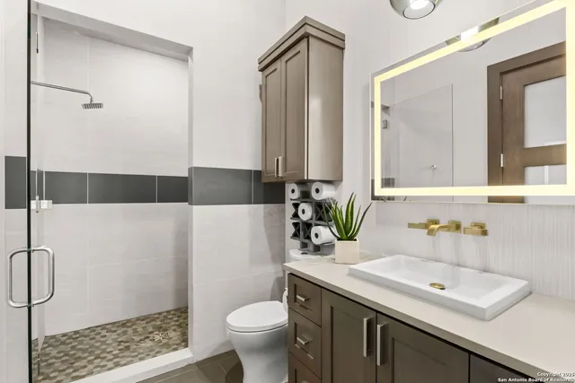 a bathroom with a sink toilet and shower