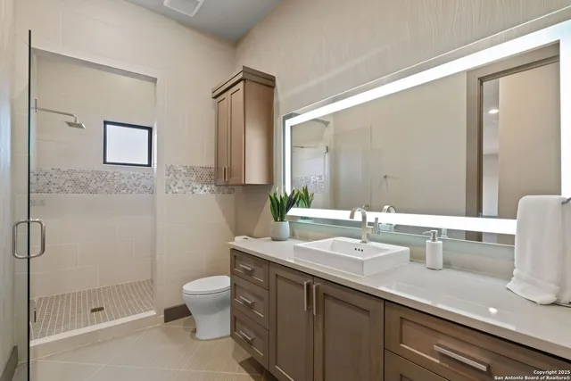 a bathroom with a granite countertop sink a toilet and a mirror