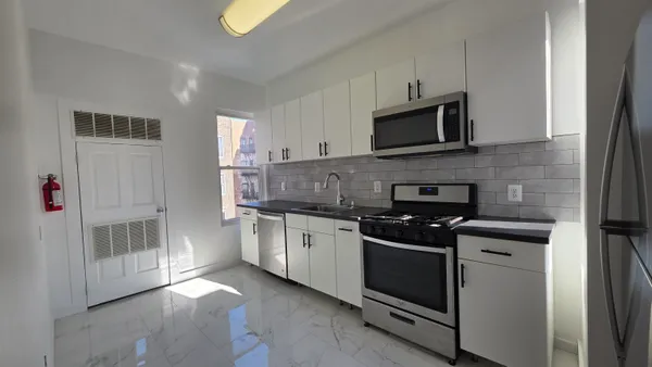 a kitchen with stainless steel appliances a refrigerator sink and cabinets