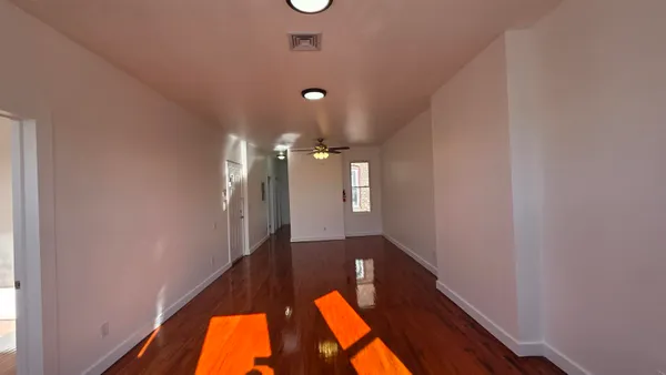 a view of an empty room and wooden floor