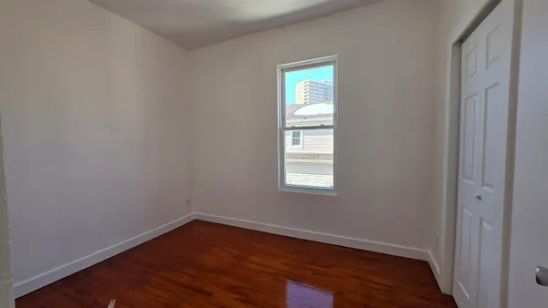 an empty room with wooden floor and closet