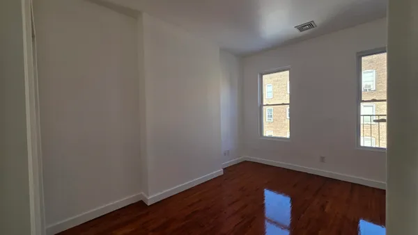a view of an empty room with wooden floor