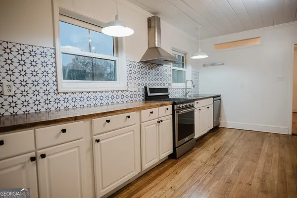 a kitchen with granite countertop white cabinets stainless steel appliances and sink