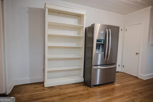 a view of empty room with wooden floor and fireplace