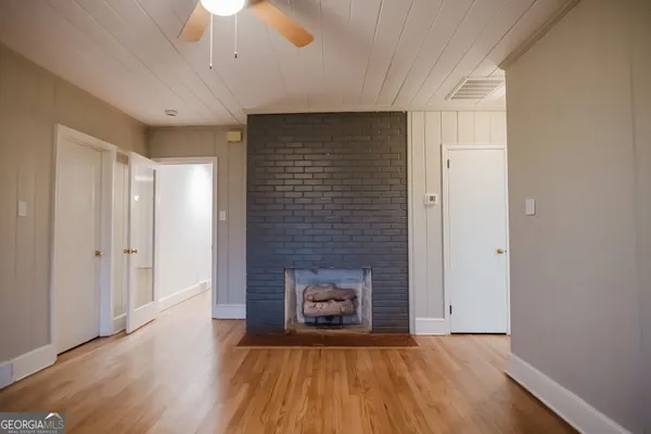 a view of a hallway with wooden floor and staircase