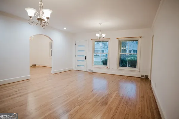 a view of an empty room with a window and wooden floor