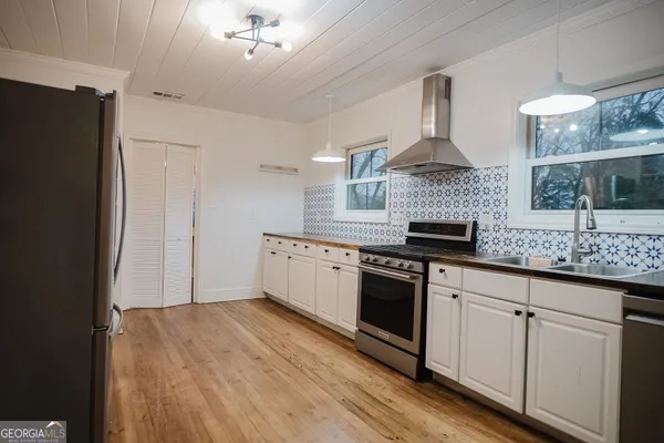a kitchen with stainless steel appliances a sink stove and refrigerator