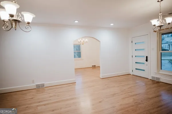 an empty room with wooden floor fireplace and staircase