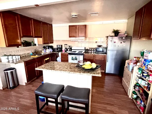 a kitchen with granite countertop a table chairs stove and cabinets