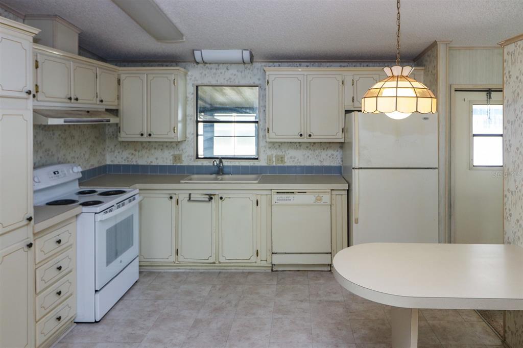 29200 South Jones Loop Road, Unit 176 Punta Gorda, FL 33950 - Photo 13 of 31 a kitchen with white cabinets and white appliances