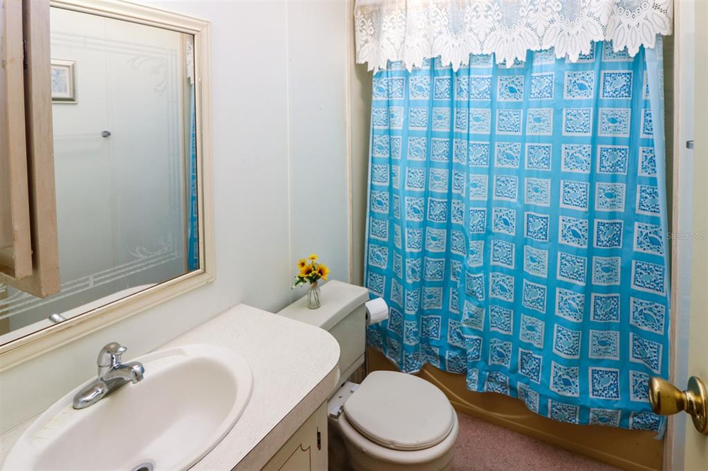 29200 South Jones Loop Road, Unit 176 Punta Gorda, FL 33950 - Photo 17 of 31 a bathroom with a sink a toilet and shower curtain