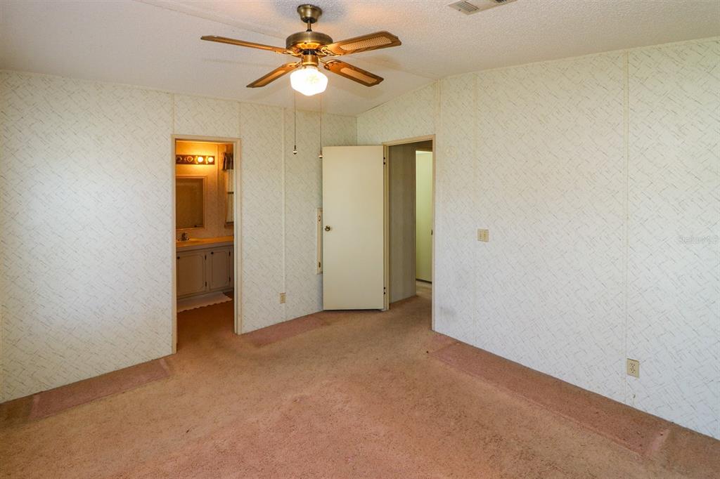 29200 South Jones Loop Road, Unit 176 Punta Gorda, FL 33950 - Photo 30 of 31 an empty room with a ceiling fan and a bathroom