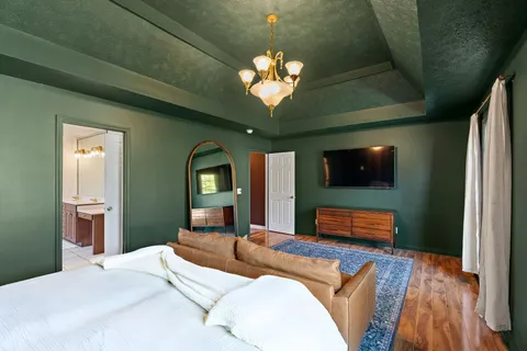 a bedroom with a bed wooden floor and window