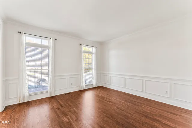 a view of a room with wooden floor and white walls