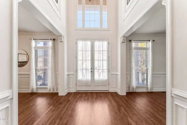 a dining room with furniture a chandelier and wooden floor