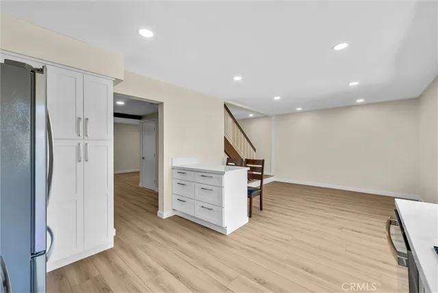 a kitchen with stainless steel appliances granite countertop a refrigerator a stove top oven a sink and dishwasher with wooden floor