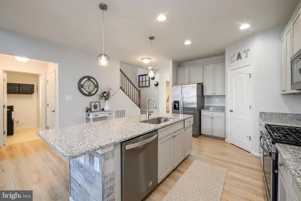 a kitchen with sink stove and refrigerator
