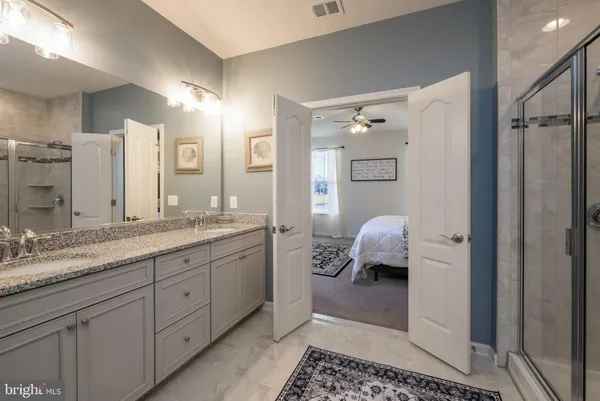 a spacious bathroom with a granite countertop sink and a mirror