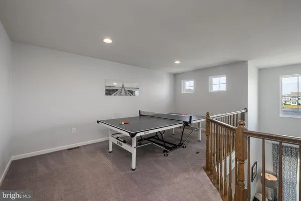 a room with furniture pool table and windows