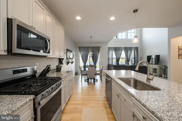 a kitchen with stainless steel appliances granite countertop a sink and a stove