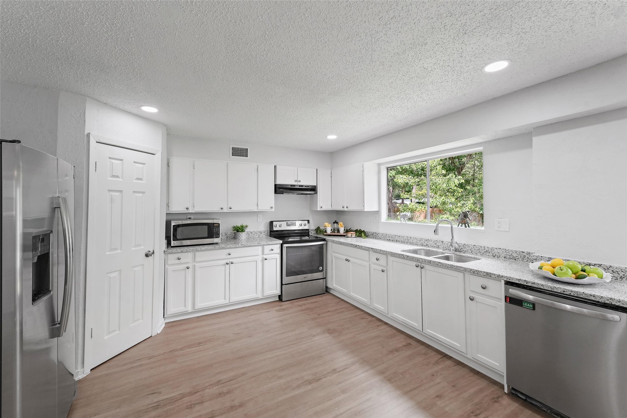 18009 Split Oak Circle New Caney, TX 77357 - Photo 1 of 30 a kitchen with a sink white cabinets a refrigerator and a stove top oven
