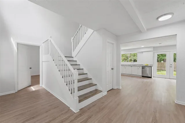 a view of a hallway with wooden floor and stairs