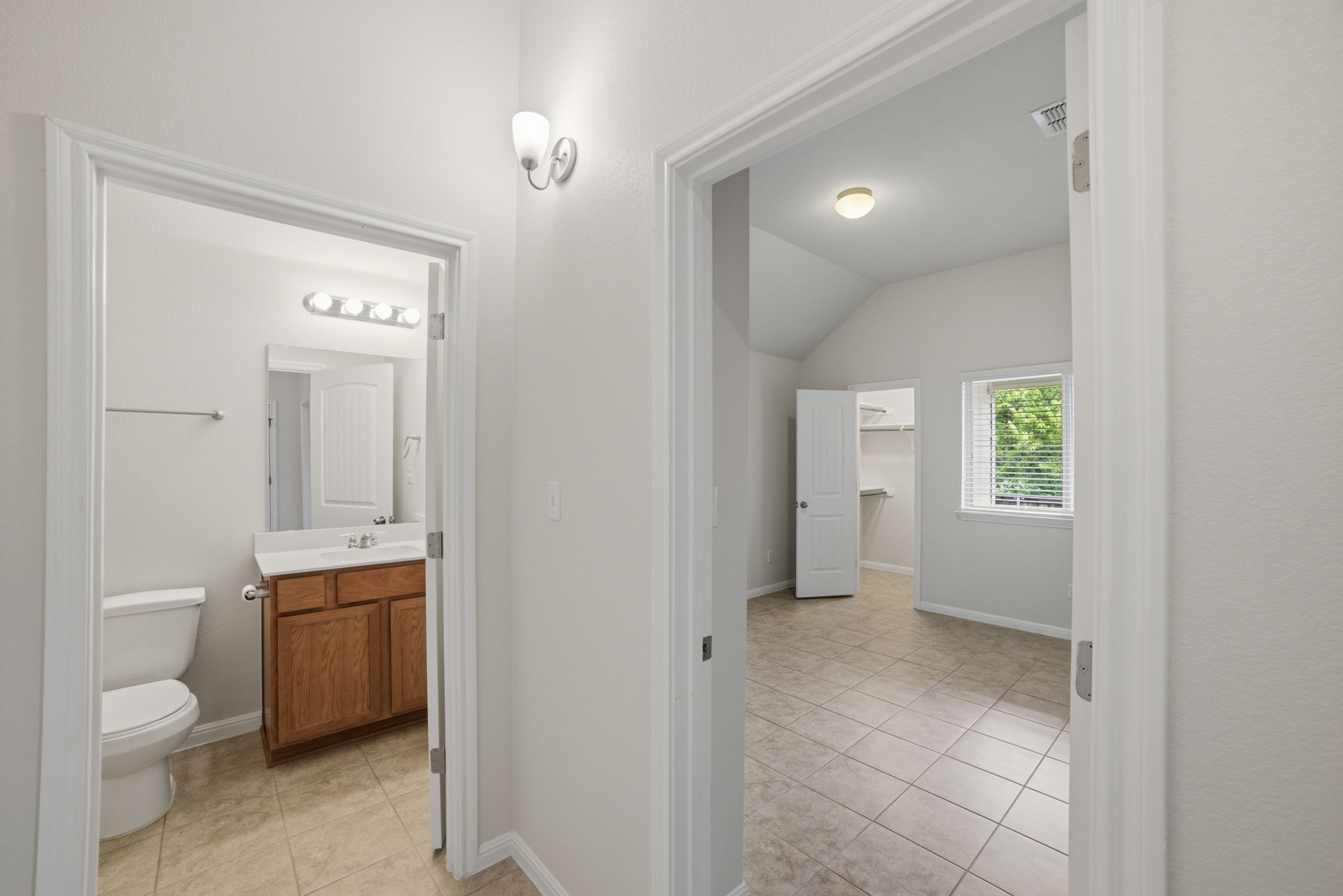 514 Nautical Loop Kyle, TX 78640 - Photo 22 of 24 A well-lit bedroom with vaulted ceilings offers a private bath and walk-in closet.