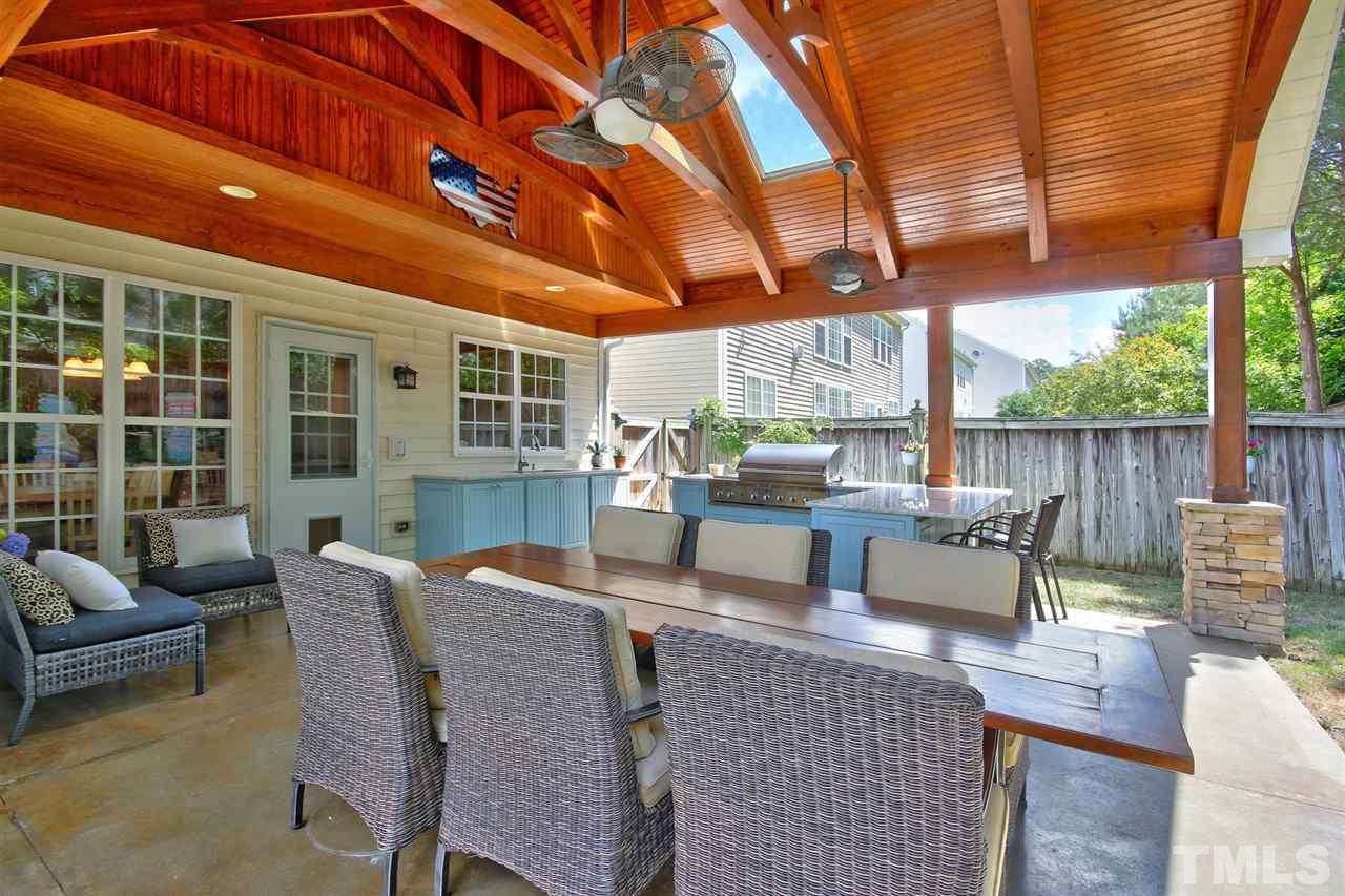 7532 Silver View Lane Raleigh, NC 27613 - Photo 24 of 30 Plenty of seating to host a feast with your friends and family! Covered by custom wooden arched beams including skylights and a ceiling fan, soak in the NC weather and relax.