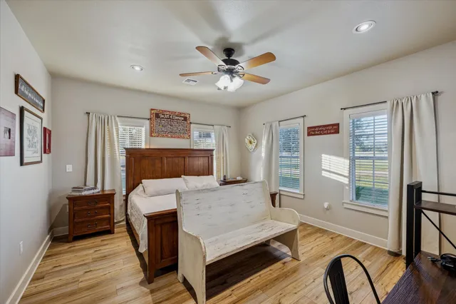 a bedroom with a bed wooden floor and window