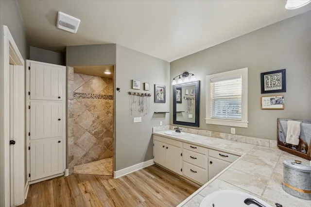 a spacious bathroom with a double vanity sink a mirror and a shower