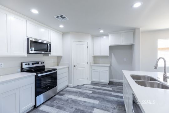 1012 Sims Street Ridgecrest, CA 93555 - Photo 11 of 36 a kitchen with a sink a stove and refrigerator