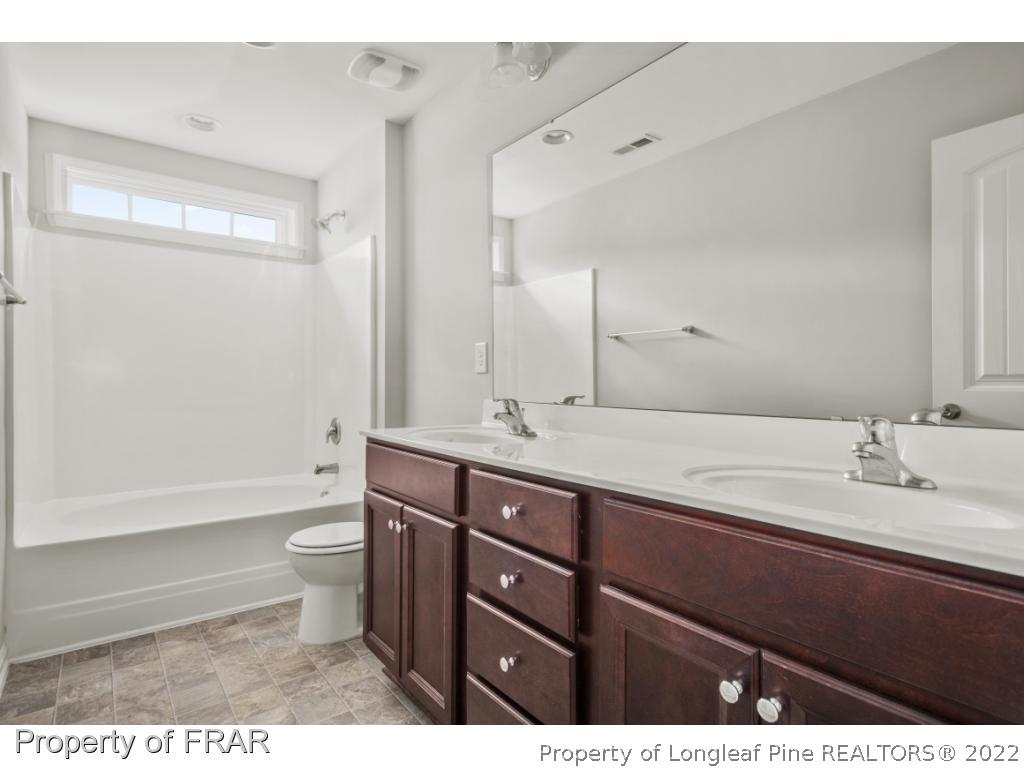 162 Watchmen Lane Cameron, NC 28326 - Photo 16 of 23 a bathroom with a granite countertop sink toilet a large mirror a bathtub and shower