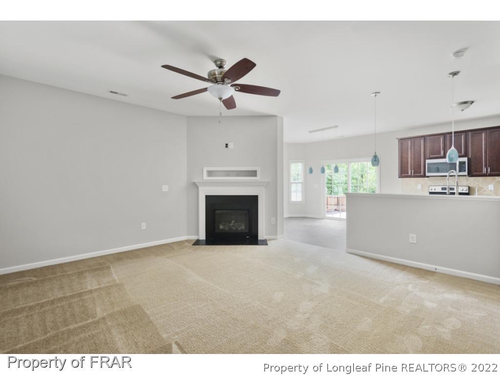 162 Watchmen Lane Cameron, NC 28326 - Photo 2 of 23 a view of a livingroom with a fireplace a ceiling fan and windows