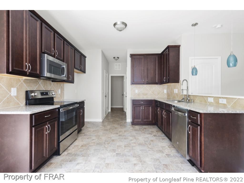 162 Watchmen Lane Cameron, NC 28326 - Photo 3 of 23 a kitchen with stainless steel appliances granite countertop a stove a sink and a microwave