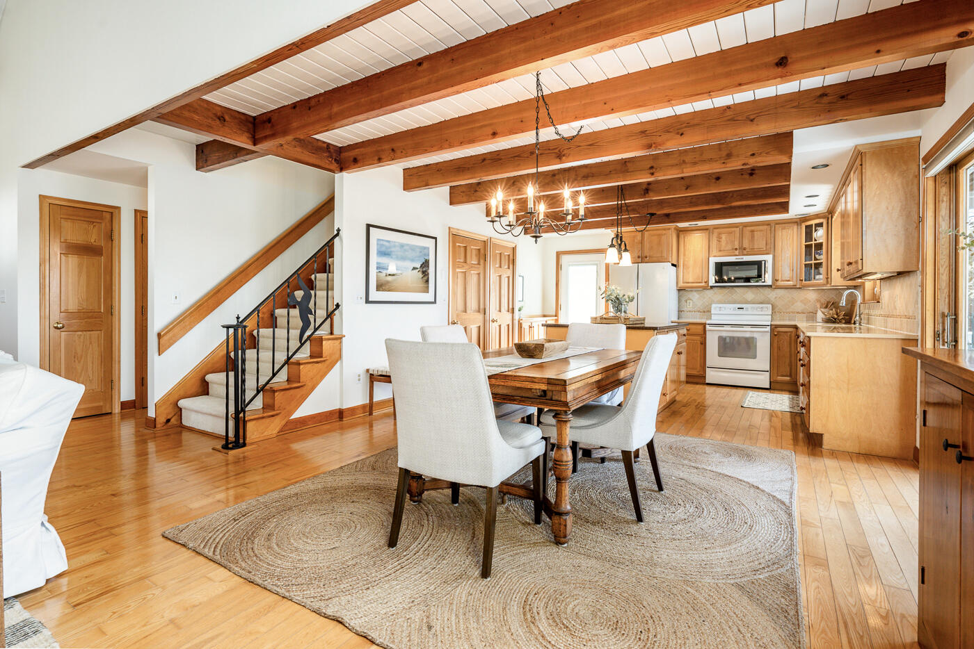 210 Lieutenant Island Road Wellfleet, MA 02667 - Photo 9 of 47 a dining room with wooden floor a chandelier a glass table and chairs