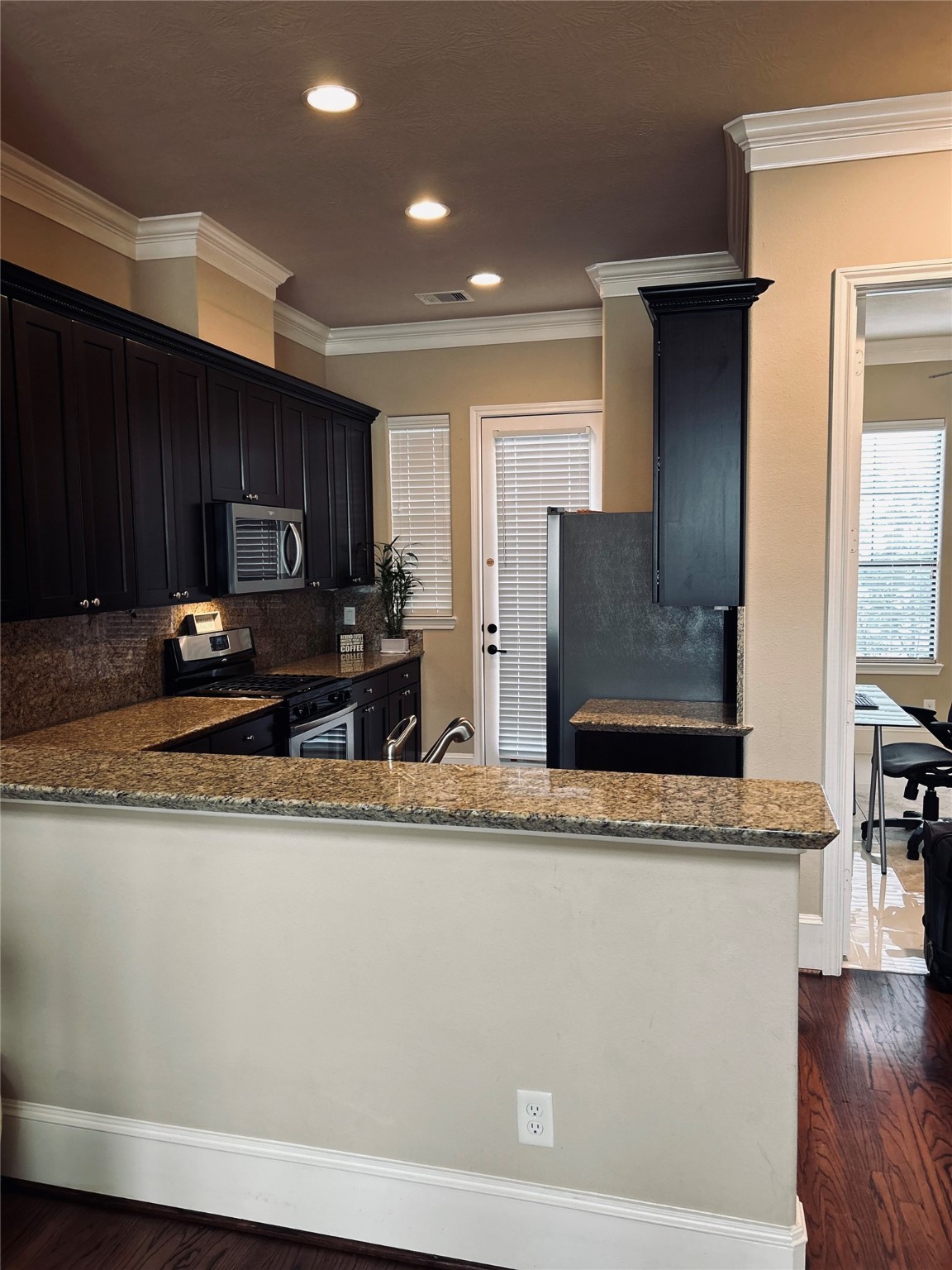 1049 West 22nd Street, Unit H Houston, TX 77008 - Photo 21 of 43 a kitchen with stainless steel appliances granite countertop a refrigerator a stove top oven a sink and dishwasher