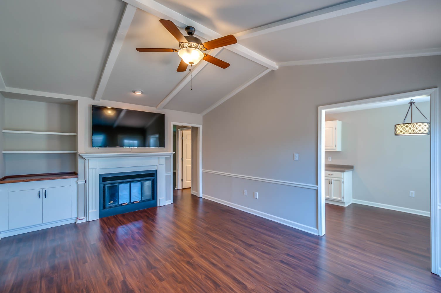 1302 General George Patton Road Nashville, TN 37221 - Photo 7 of 14 an empty room with wooden floor a ceiling fan and a fireplace