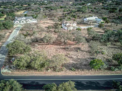 an aerial view of residential houses with outdoor space and trees