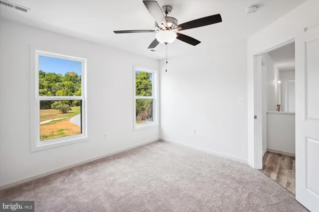 an empty room with a ceiling fan and a fan