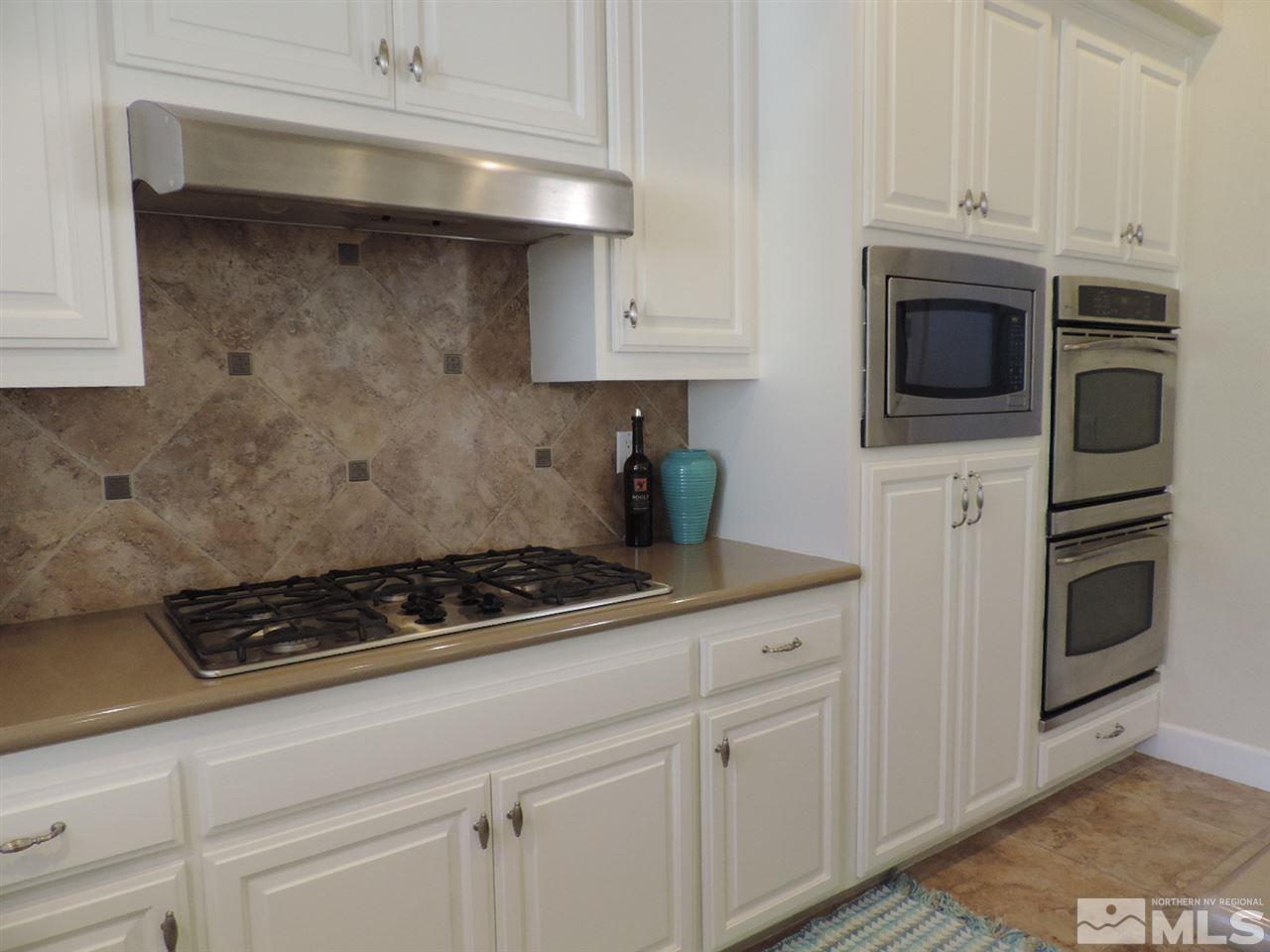 8588 Timaru Trail Reno, NV 89523 - Photo 7 of 25 a kitchen with white cabinets and stainless steel appliances
